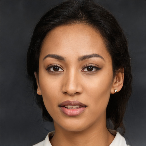 Joyful latino young-adult female with long  brown hair and brown eyes
