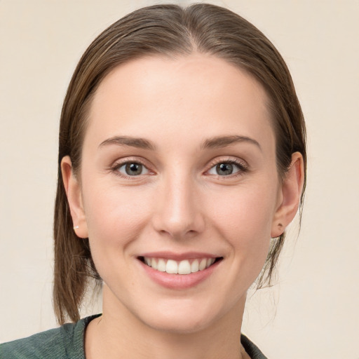 Joyful white young-adult female with medium  brown hair and grey eyes