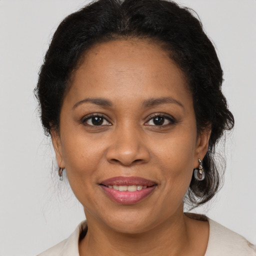 Joyful black adult female with medium  brown hair and brown eyes