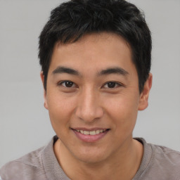 Joyful asian young-adult male with short  black hair and brown eyes