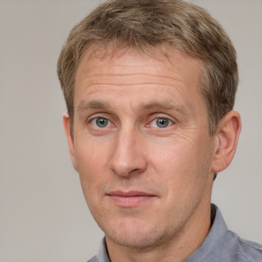 Joyful white adult male with short  brown hair and grey eyes