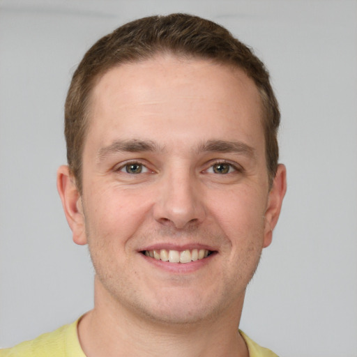 Joyful white young-adult male with short  brown hair and grey eyes