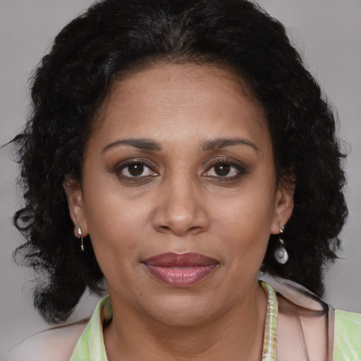 Joyful latino adult female with medium  brown hair and brown eyes