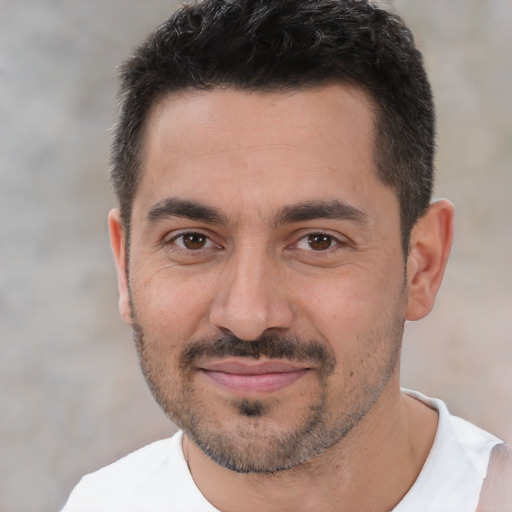 Joyful white adult male with short  black hair and brown eyes