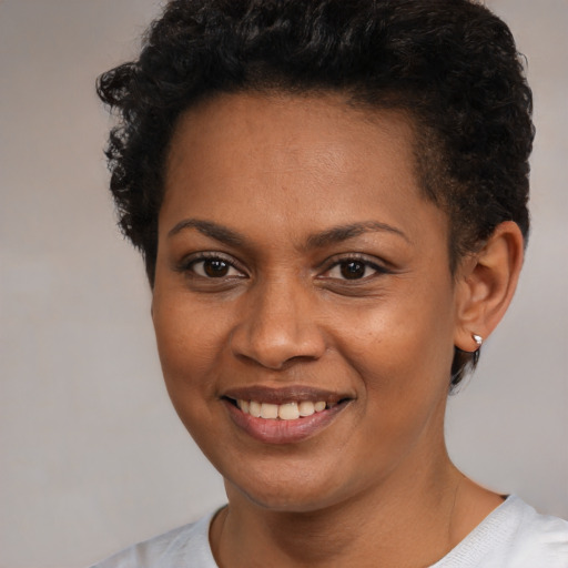 Joyful black young-adult female with short  brown hair and brown eyes