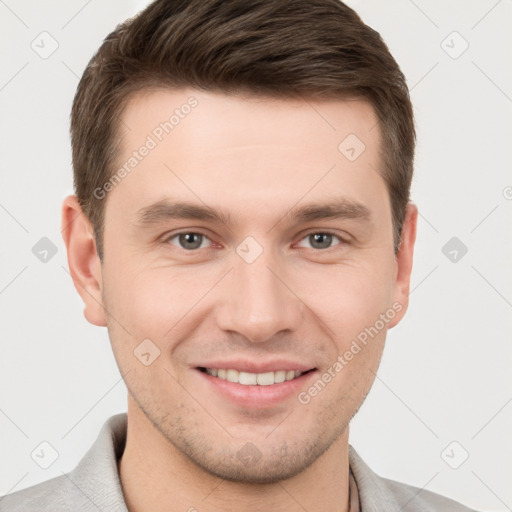 Joyful white young-adult male with short  brown hair and grey eyes