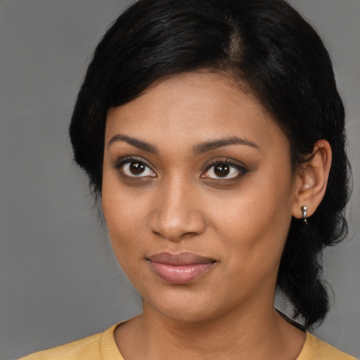 Joyful black young-adult female with medium  black hair and brown eyes