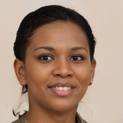 Joyful black young-adult female with long  brown hair and brown eyes