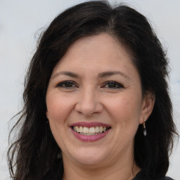 Joyful white adult female with long  brown hair and brown eyes