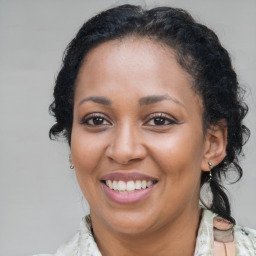 Joyful black adult female with medium  brown hair and brown eyes