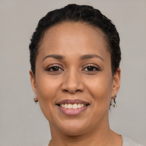 Joyful black adult female with short  black hair and brown eyes