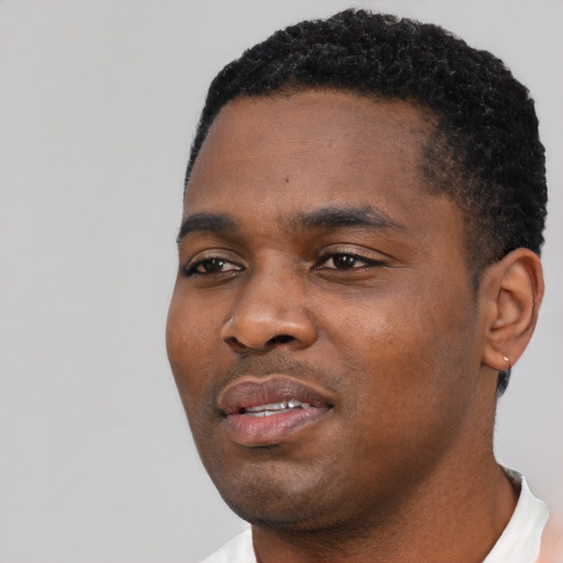 Joyful black young-adult male with short  black hair and brown eyes