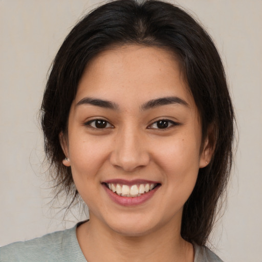 Joyful asian young-adult female with medium  brown hair and brown eyes