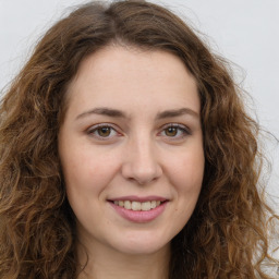 Joyful white young-adult female with long  brown hair and green eyes