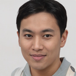 Joyful asian young-adult male with short  brown hair and brown eyes