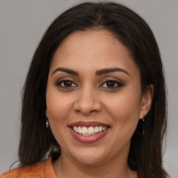 Joyful latino young-adult female with long  brown hair and brown eyes