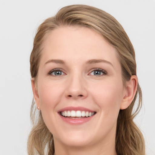 Joyful white young-adult female with long  brown hair and blue eyes