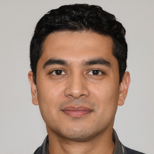 Joyful latino young-adult male with short  black hair and brown eyes