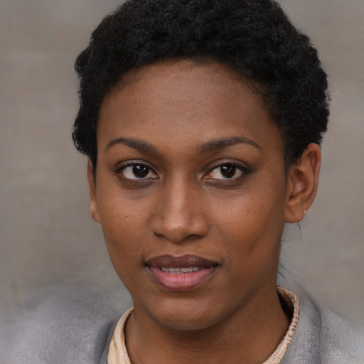 Joyful black young-adult female with short  black hair and brown eyes