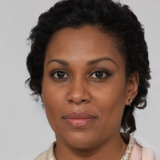 Joyful black adult female with short  brown hair and brown eyes