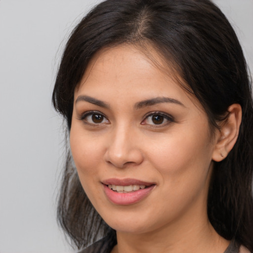 Joyful latino young-adult female with long  brown hair and brown eyes