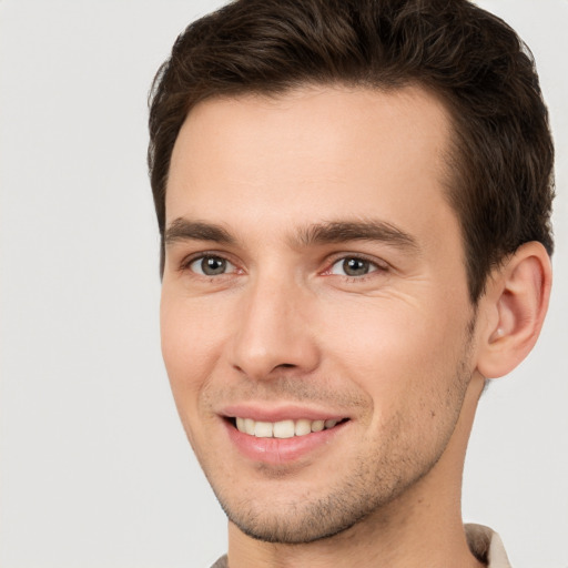 Joyful white young-adult male with short  brown hair and brown eyes