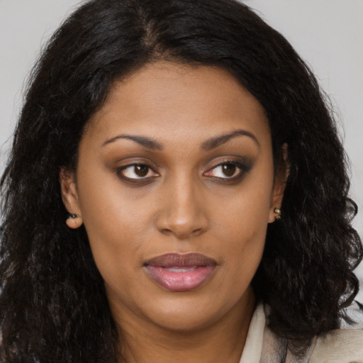 Joyful black young-adult female with long  brown hair and brown eyes