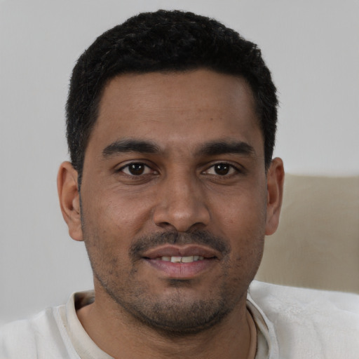 Joyful latino young-adult male with short  brown hair and brown eyes