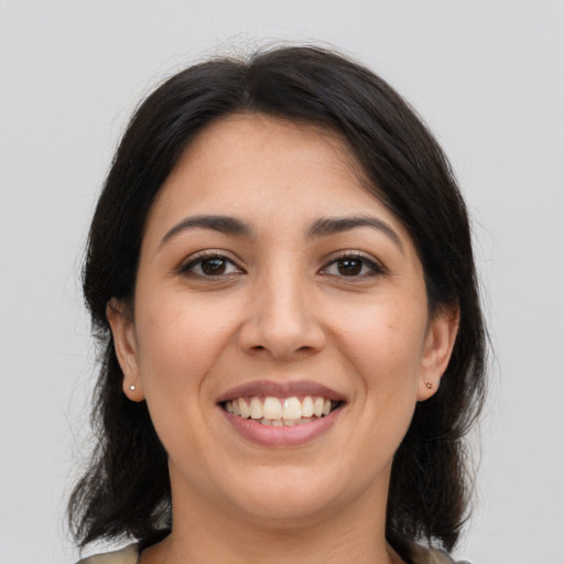 Joyful latino young-adult female with medium  brown hair and brown eyes