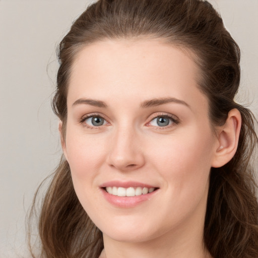 Joyful white young-adult female with long  brown hair and grey eyes