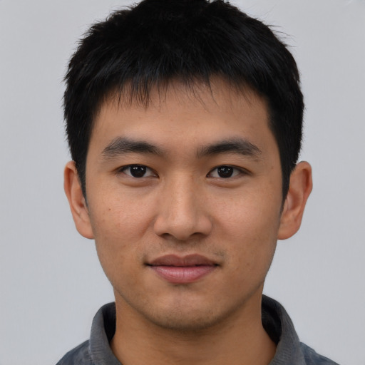 Joyful asian young-adult male with short  black hair and brown eyes