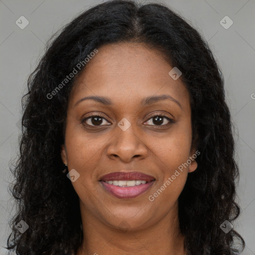 Joyful black young-adult female with long  brown hair and brown eyes