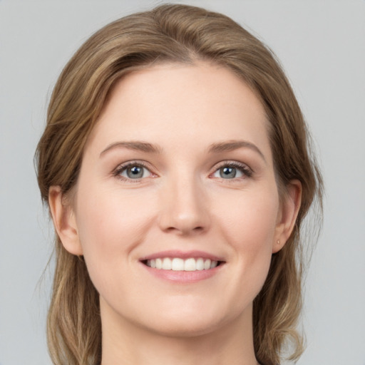 Joyful white young-adult female with medium  brown hair and grey eyes