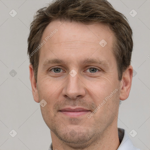 Joyful white adult male with short  brown hair and grey eyes