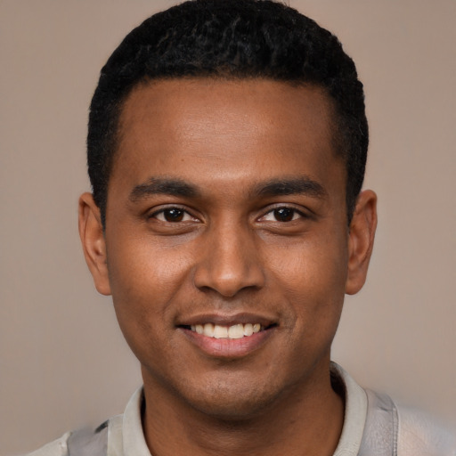 Joyful black young-adult male with short  black hair and brown eyes