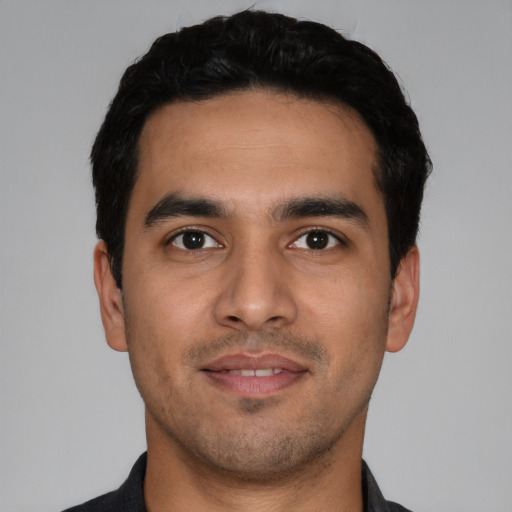 Joyful latino young-adult male with short  black hair and brown eyes