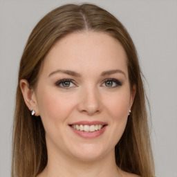 Joyful white young-adult female with long  brown hair and grey eyes