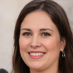 Joyful white adult female with long  brown hair and brown eyes