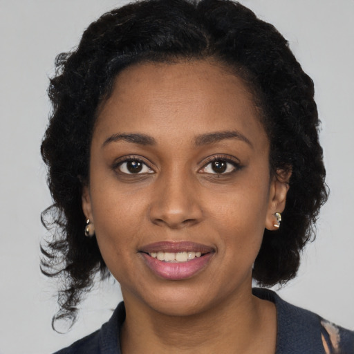 Joyful black young-adult female with medium  brown hair and brown eyes