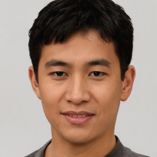 Joyful asian young-adult male with short  black hair and brown eyes