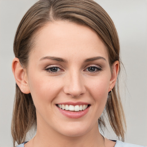 Joyful white young-adult female with medium  brown hair and grey eyes