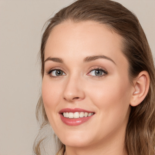 Joyful white young-adult female with long  brown hair and blue eyes