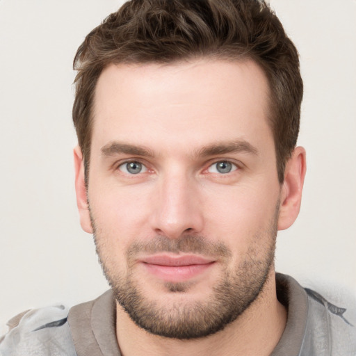 Joyful white young-adult male with short  brown hair and grey eyes