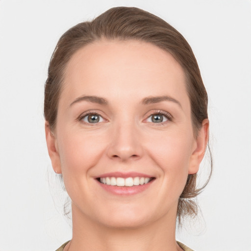 Joyful white young-adult female with medium  brown hair and grey eyes