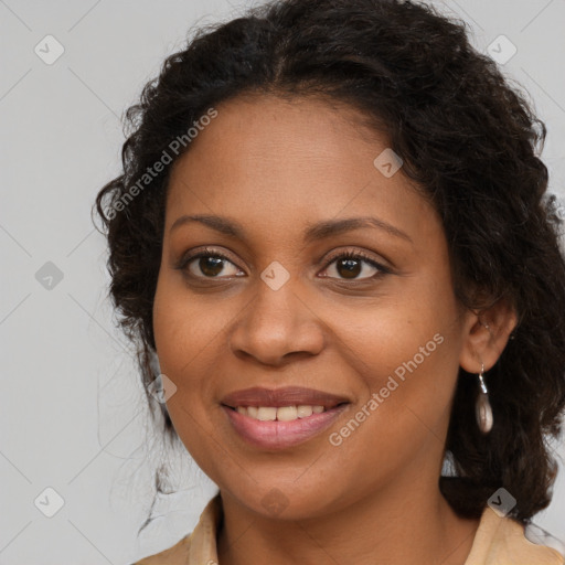 Joyful black young-adult female with long  brown hair and brown eyes