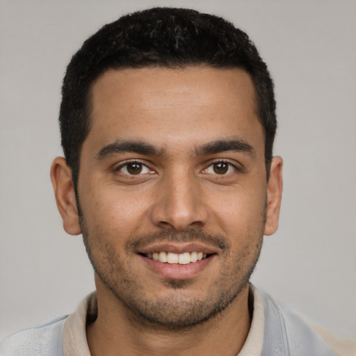 Joyful latino young-adult male with short  black hair and brown eyes