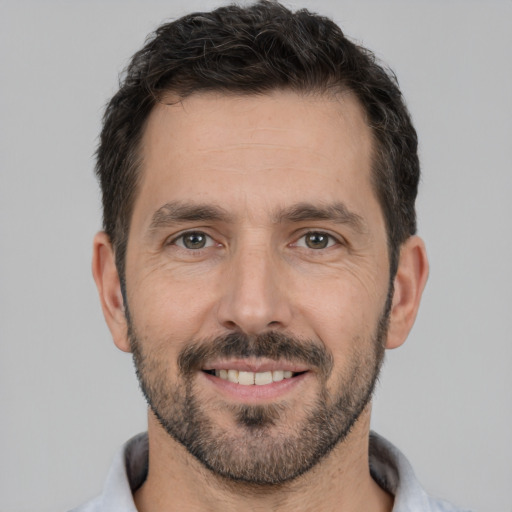 Joyful white young-adult male with short  black hair and brown eyes