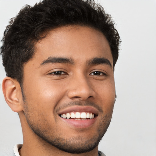 Joyful latino young-adult male with short  brown hair and brown eyes