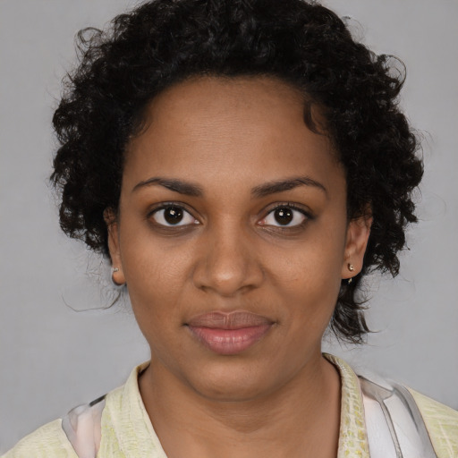 Joyful black young-adult female with short  brown hair and brown eyes