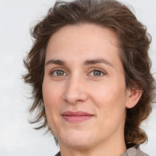 Joyful white adult female with medium  brown hair and green eyes